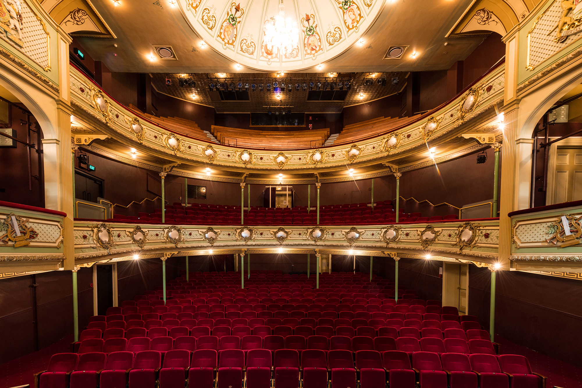 A view of the Theatre Royal stage as if you're standing on the stage looking out into the red seating bank. 