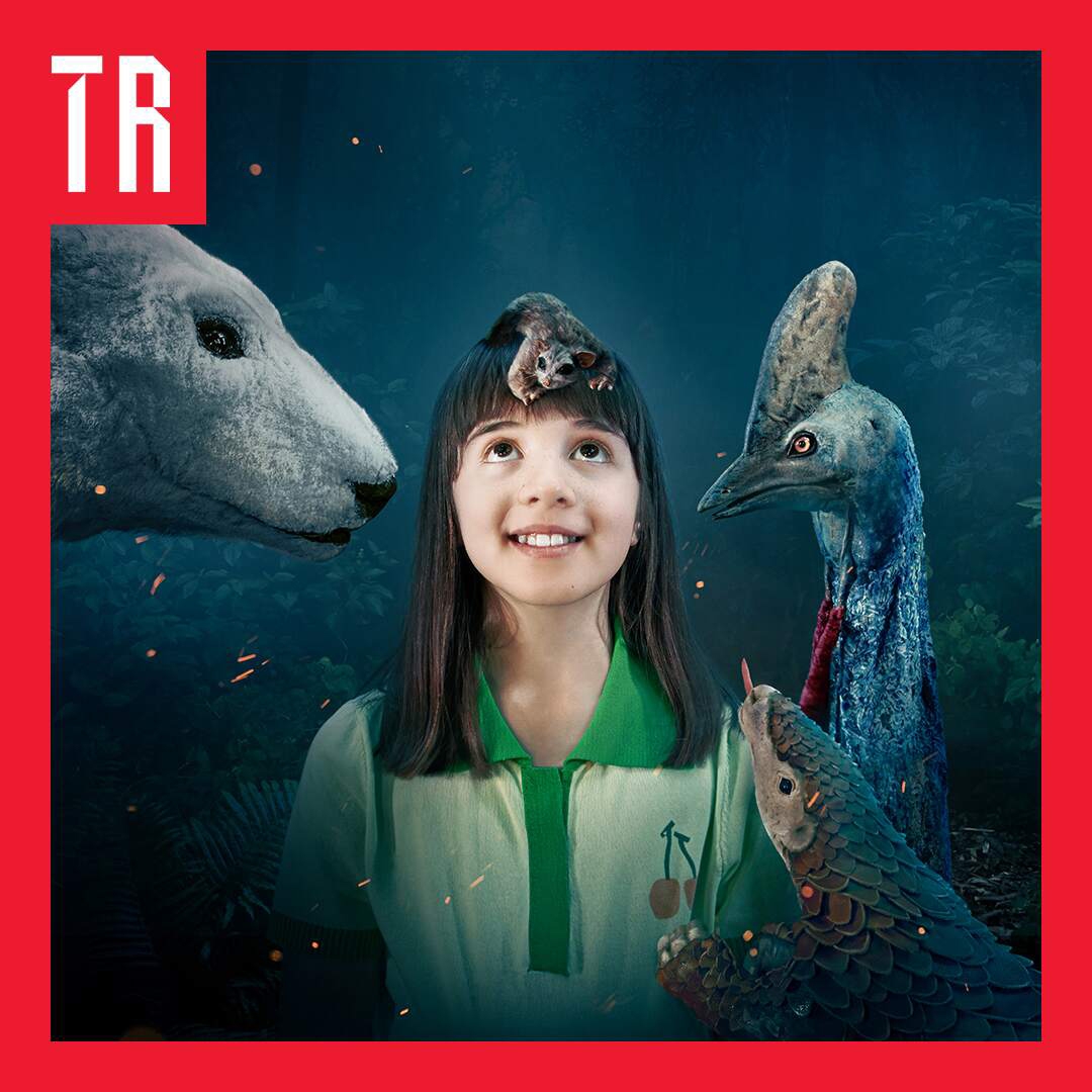 Image: Supplied by Arts on Tour A young girl looks upward in the middle of the image. She has a puppet of a possum sitting on her head. To her left, a puppet of a polar bear and to her right a puppet of a cassowary and another animal that I'm not sure what it is.
