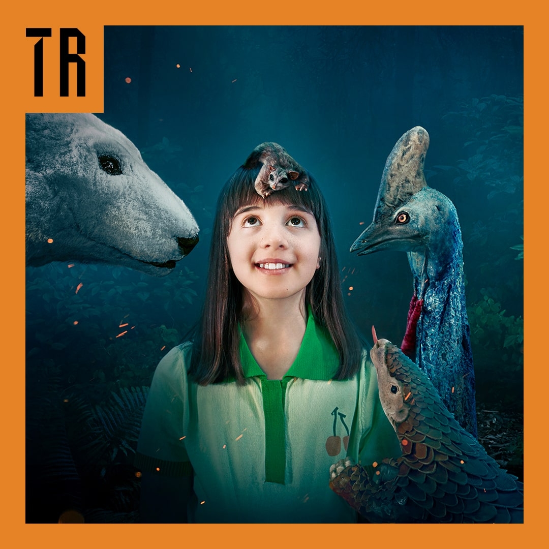 ARC A girl in the middle of the frame looks upward. Shes surrounded by endangered animal puppets.