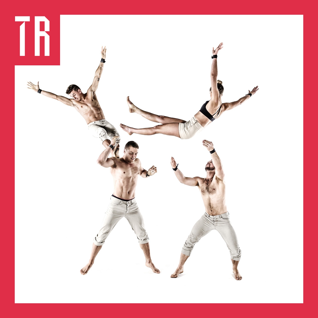 Four acrobats on a white background. Two are flying through the air as if they have just been thrown in to the air by the other two who are on the ground
