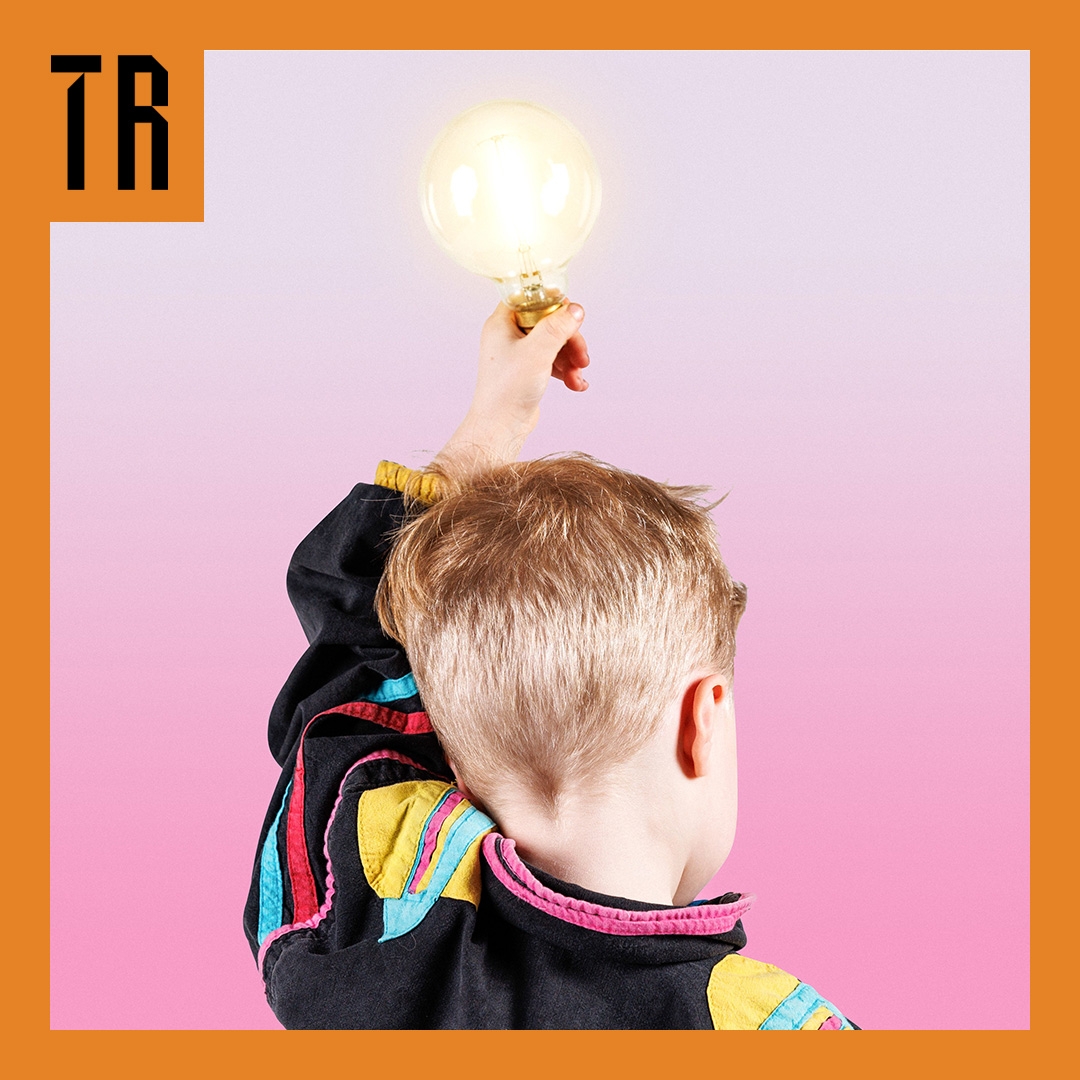 Then What?! hero image version 2 A child stands with his back to us. He is holding a light bulb above his head, it is glowing brightly.