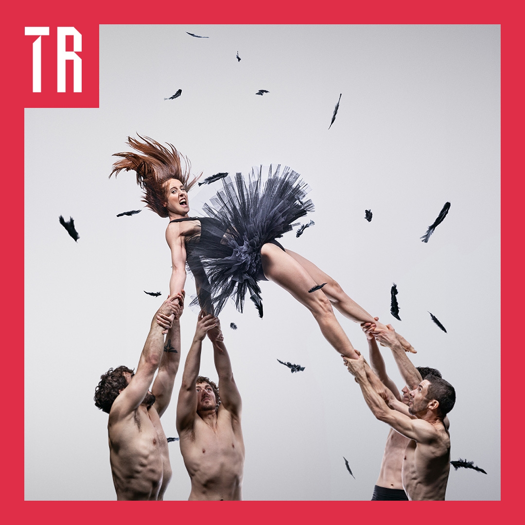 Photo: Damien Bredberg A woman in a grey tu-tu type skirt is lifted in o the air by four bare chested men.