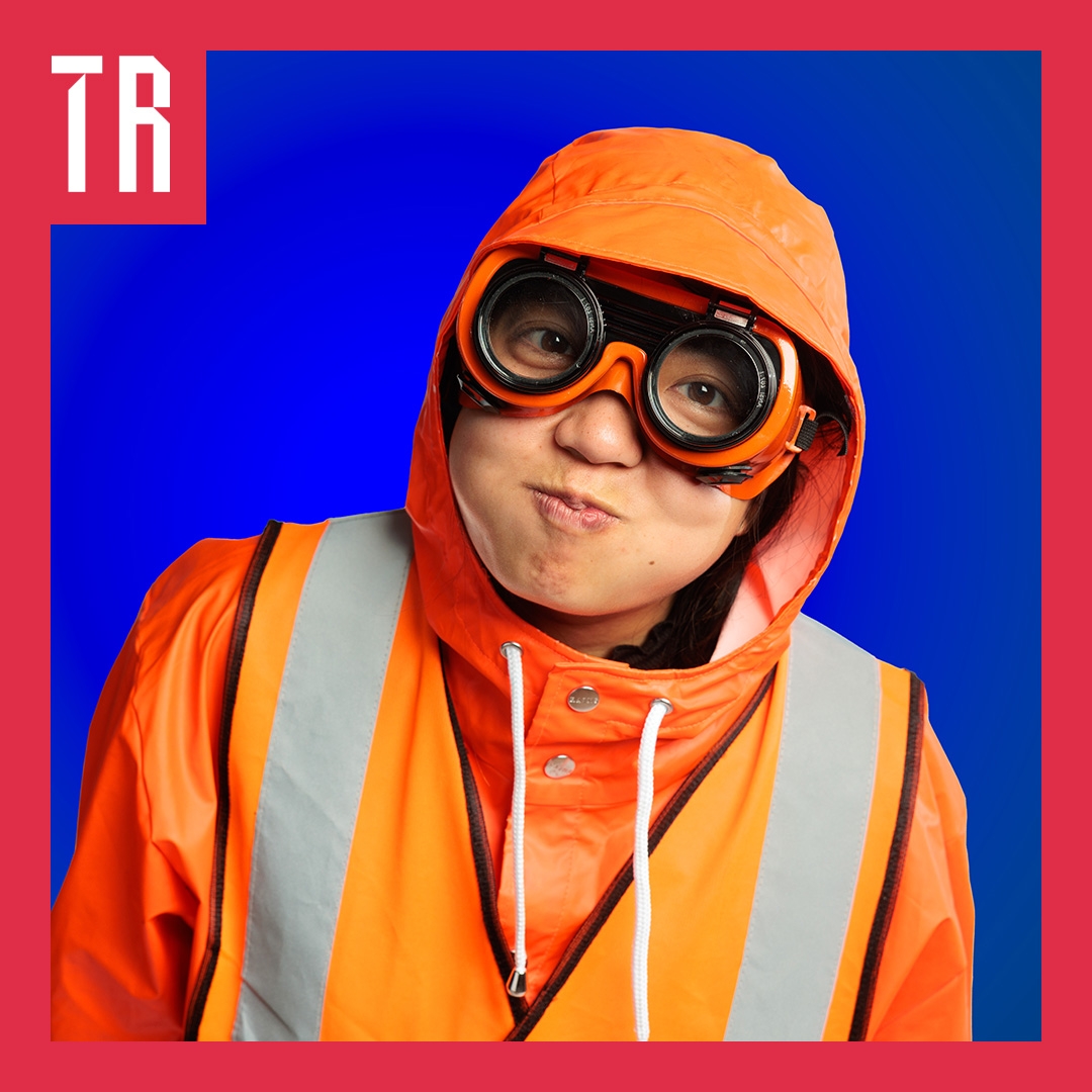Photo: Peter Mathew A person dressed in bright orange wetwaether clothes with large goggles, pulls a funny face like they are holding their breath