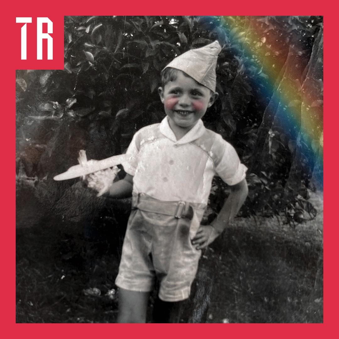A black and white photo of a young boy in the 50s, holding a toy plane.