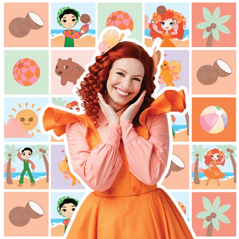 Emma Memma A woman with bright red hair and orange clothes smiles happily