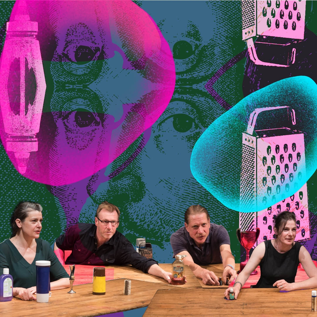 A group of four actors sit behind a table, they are reaching out for inanimate objects