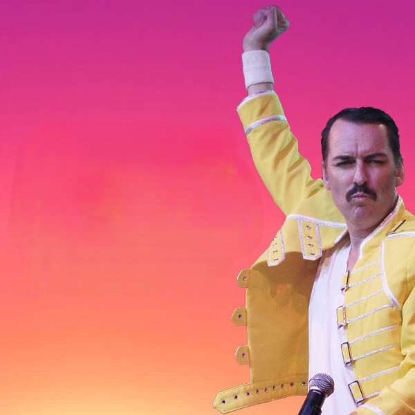Image: supplied A man stands agains a pink and orange background. He is wearing a yellow coat and has his arm raised in the air mid flamboyant gesture