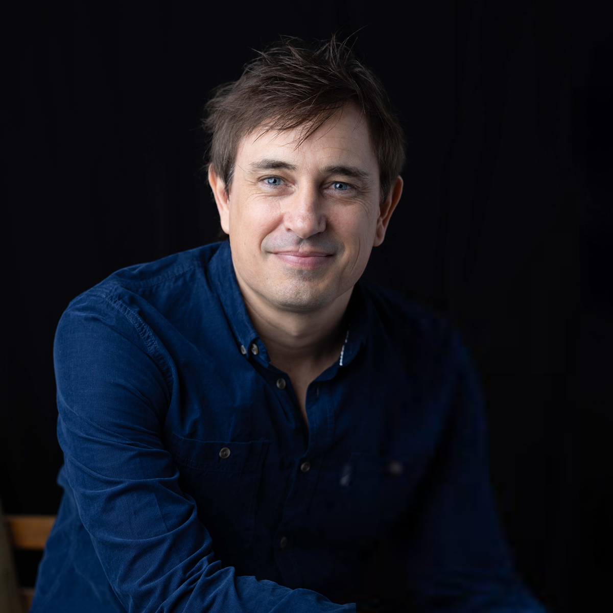 Trent Dalton portrait A colour, portrait photo of Trent Dalton a man wears a blue shirt