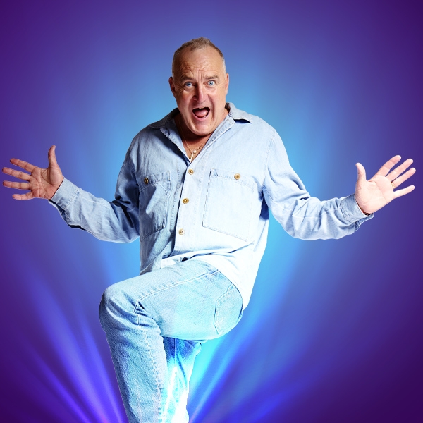 Image: supplied Jimeoin, the comedian, stands is a mock surprise pose, he is wearing double denim, his hands are raised to his side