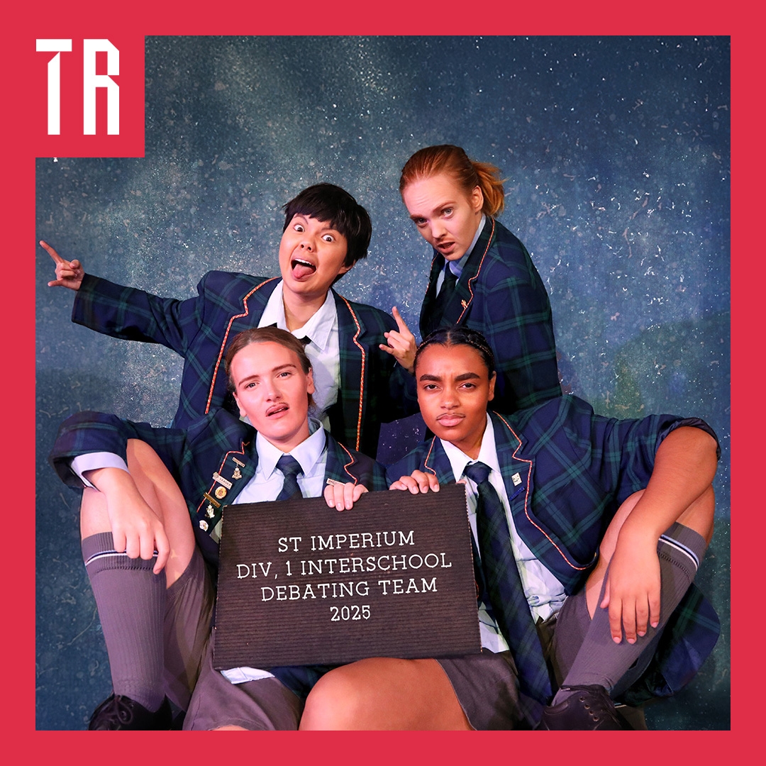Photo: Ben Andrews Four non binary and female actors are dressed as elite private school boys, they pose in a cheeky way behind a signs that says St Ignatius debating team