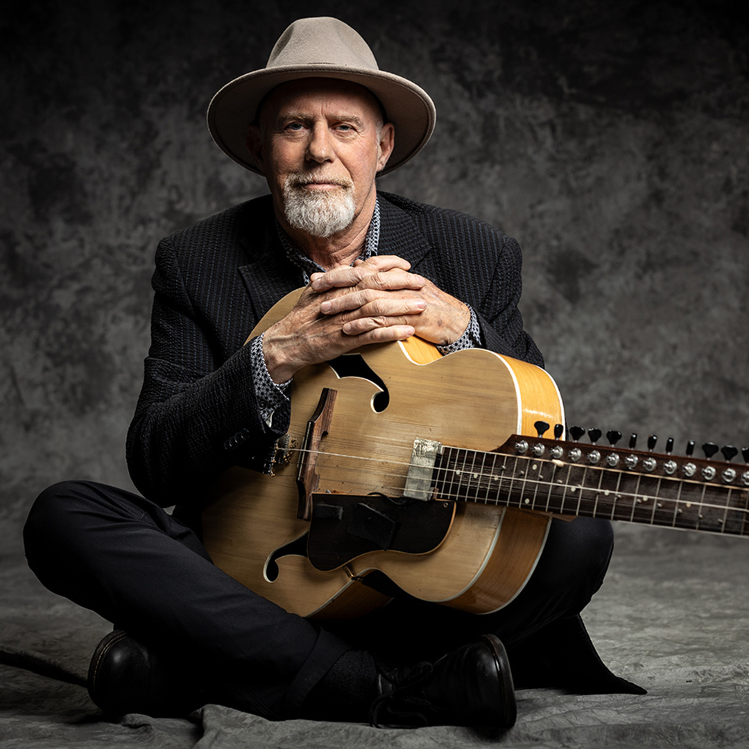 A portrait of guitarist Harry Manx