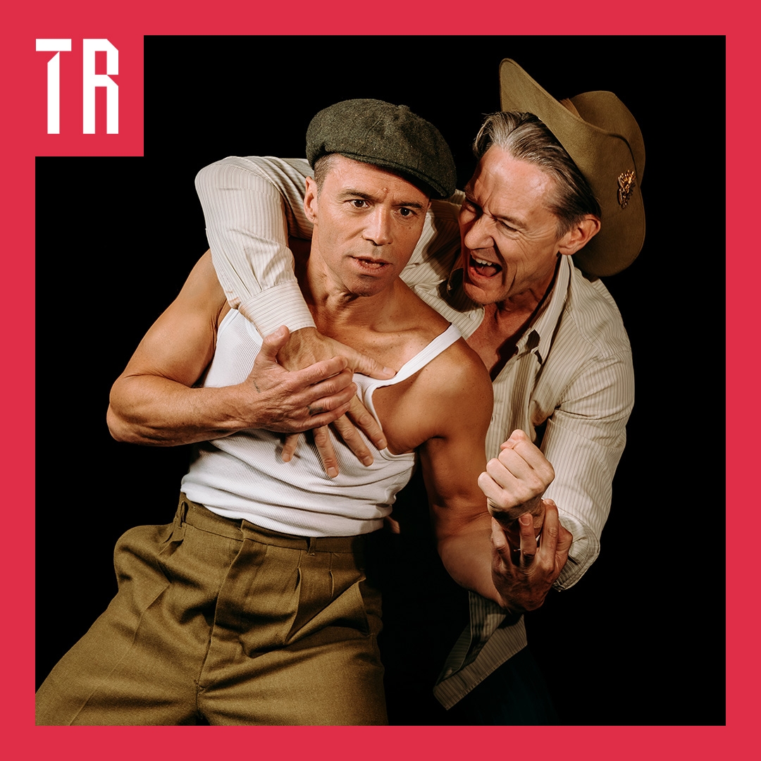 Two men in post war Australian clothes wrestle playfully