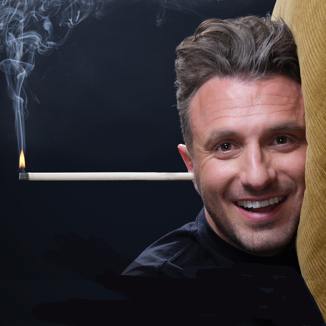 Portrait of comedian Tommy Little. His head is lying on a pillow with an ear candle sticking out of his ear