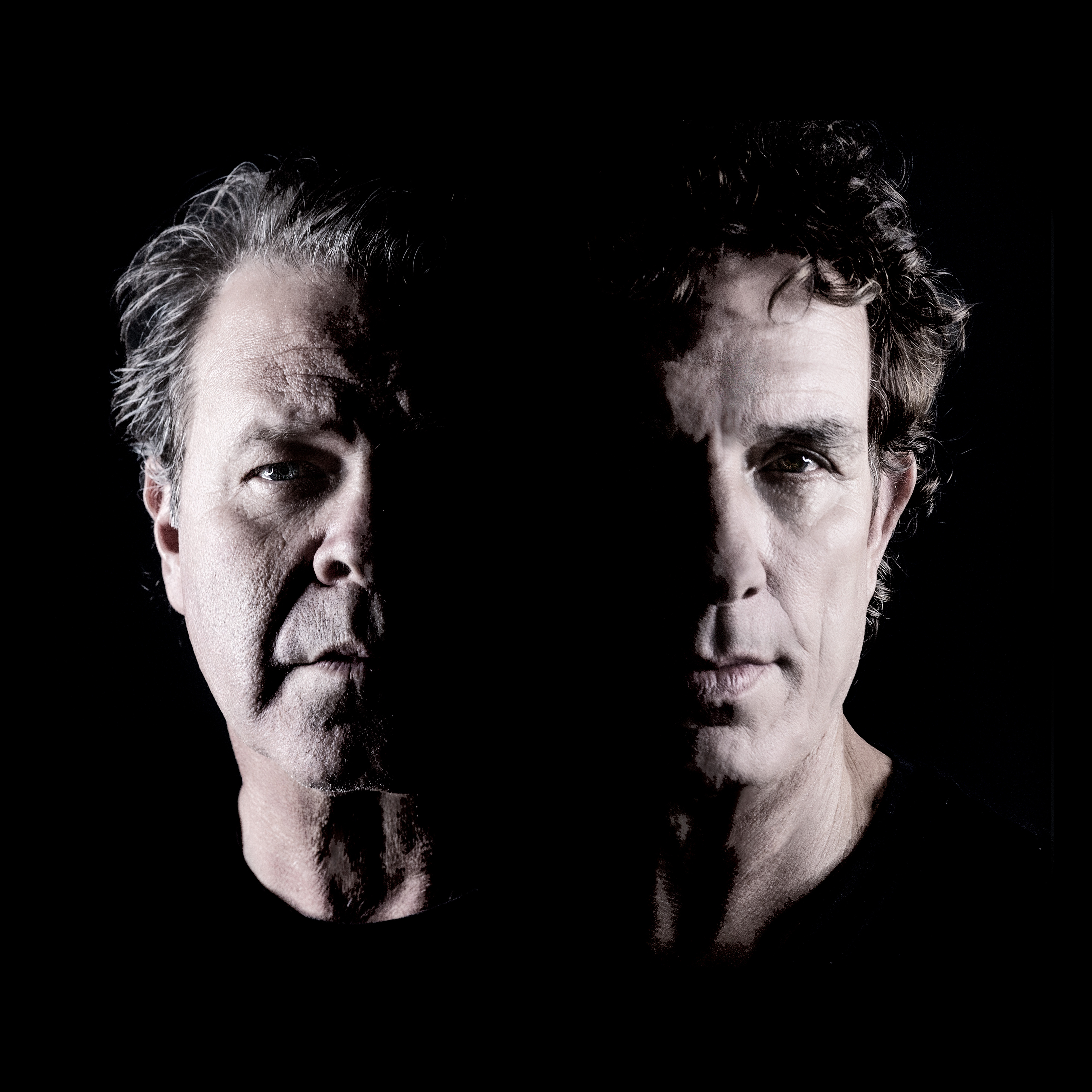 A black and white portrait of  Ian Moss + Troy Cassar-Daley. A close up head shot, like a roman statue, each mans face is half illuminated by light