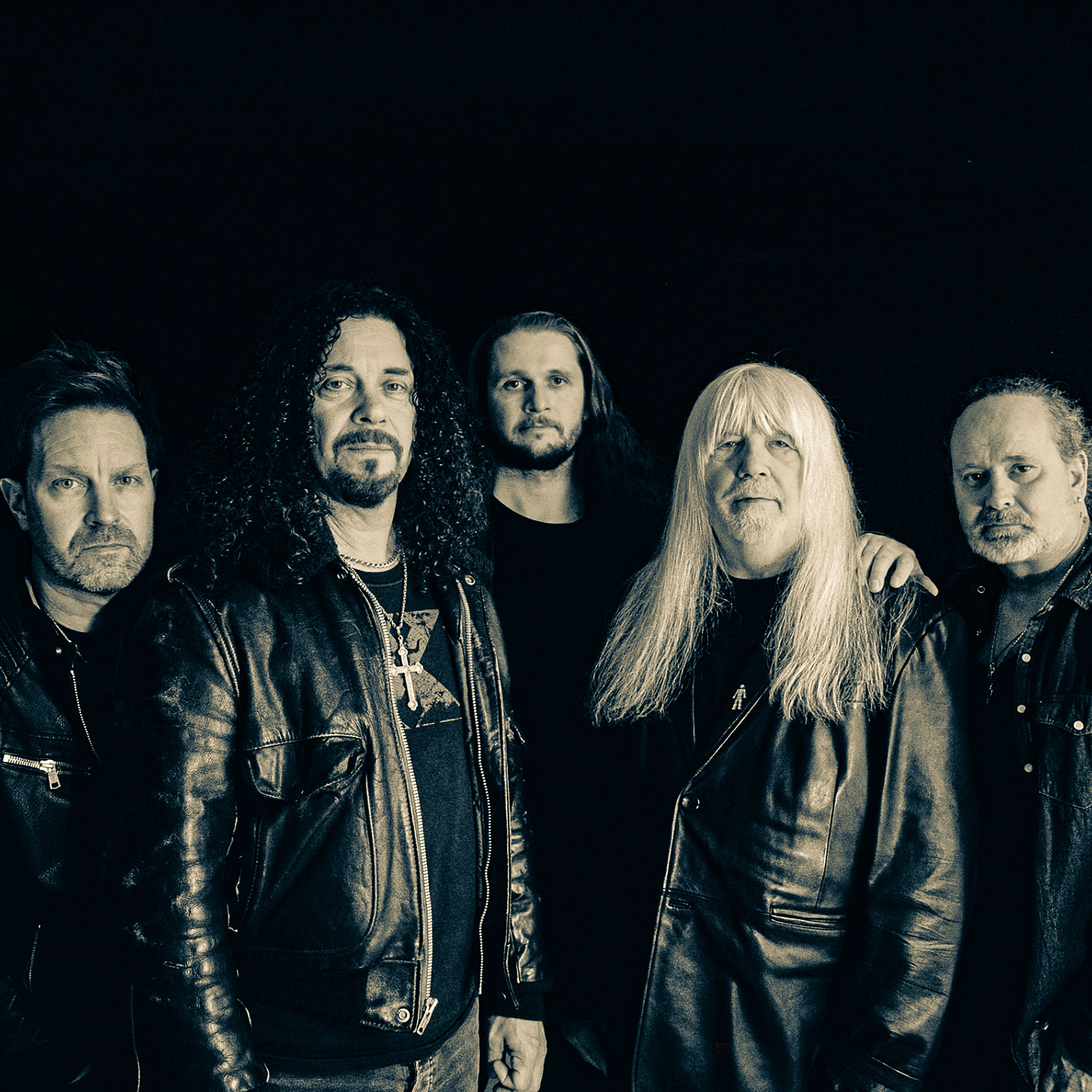 a black and white portrait of UK 70's glam rock band The Sweet. It features four men of various ages in black leather jackets