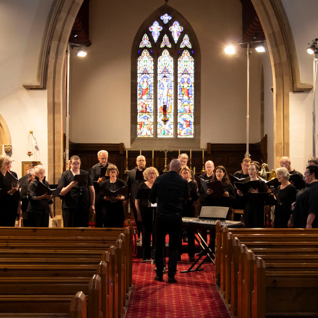 Allegri Ensemble wearing black, performing in a church