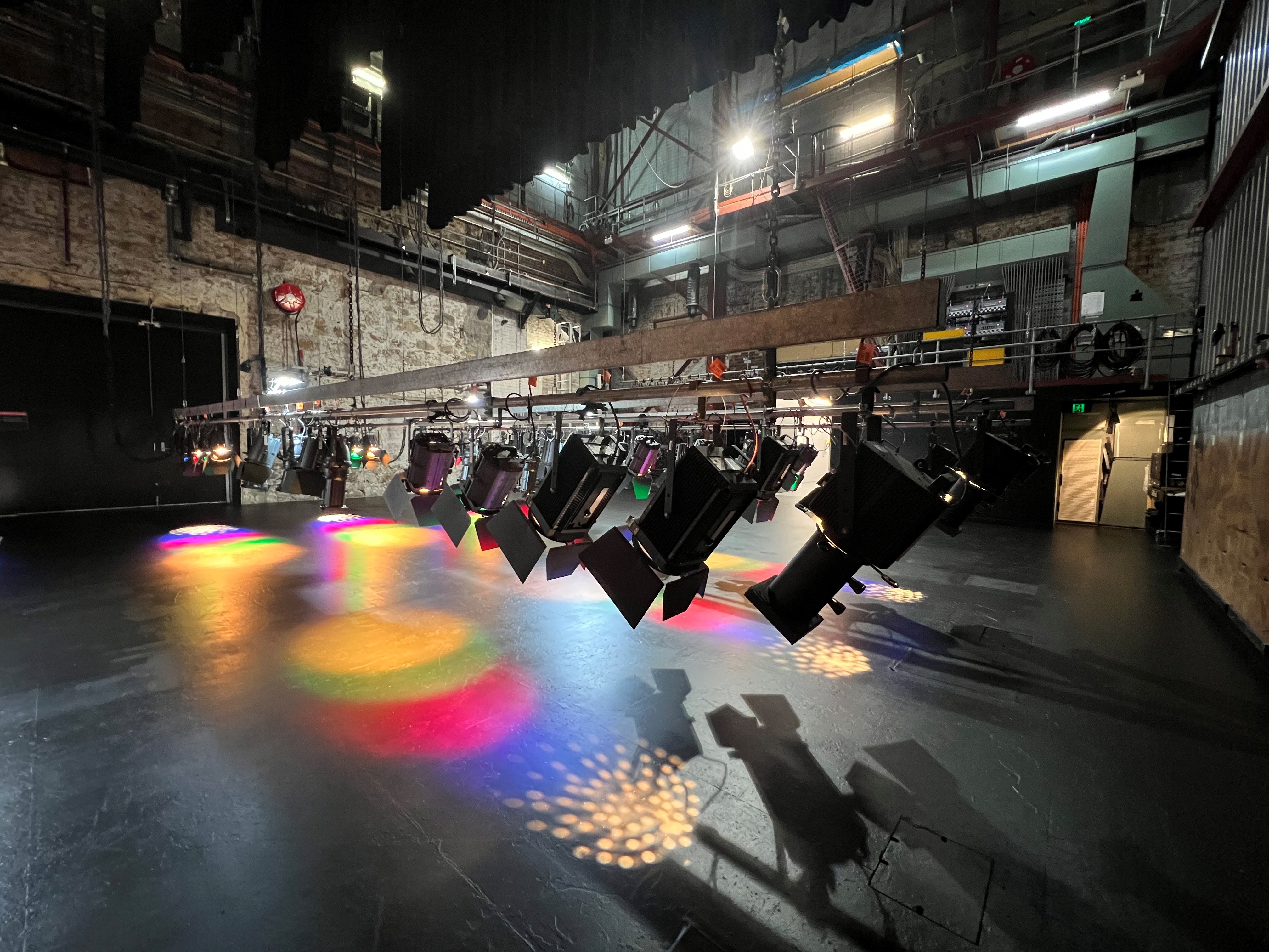 Back stage at the Theatre Royal Back stage area of the Theatre Royal. A row of lights are pointing towards the stage with blue, red, green and yellow colours