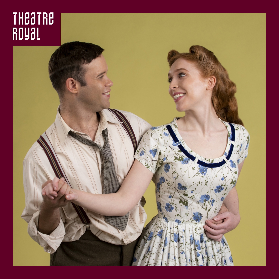 A man and women look towards each other. They are holding a pose that looks like they are dancing. The clothing they are wearing looks like it's from the 40's.
