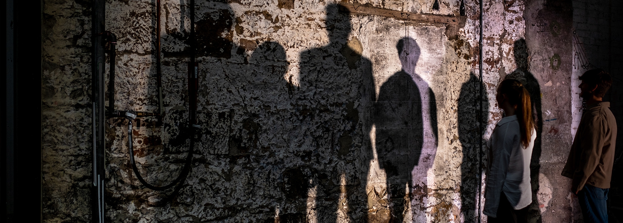 Shadows Human shaped shadows projected agains a textures historical wall